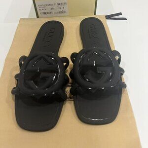 These Gucci women's sandals are slip-on slides in a black color. They feature th
